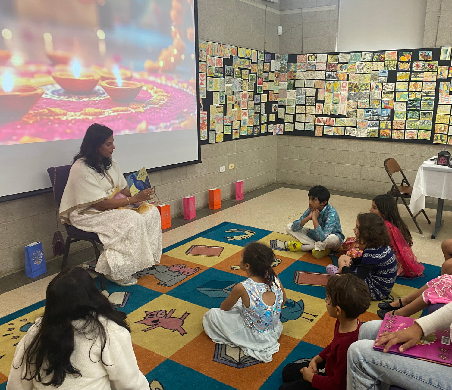 Teacher with students in a classroom setting with educational materials on the walls.